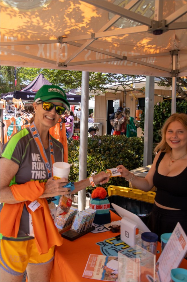 Staff handing Char Tickets to runners at an activation table
