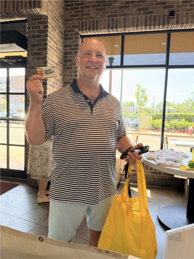 Guest inside a Habit Burger location holding a Char Ticket and takeout bag